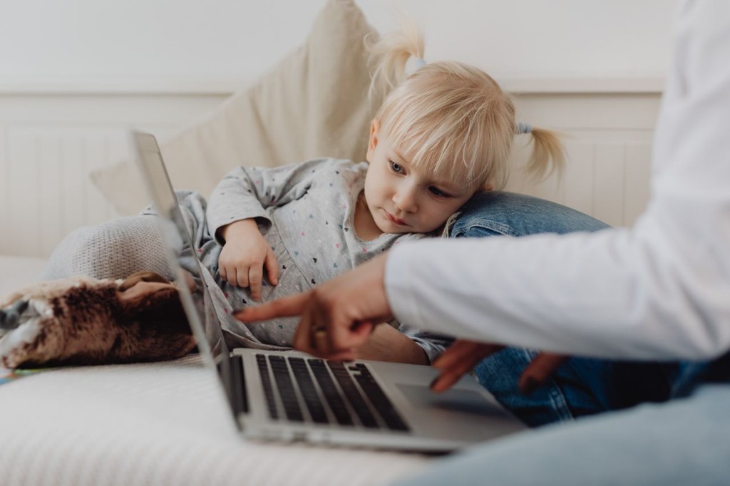Child and caregiver using a laptop for telehealth